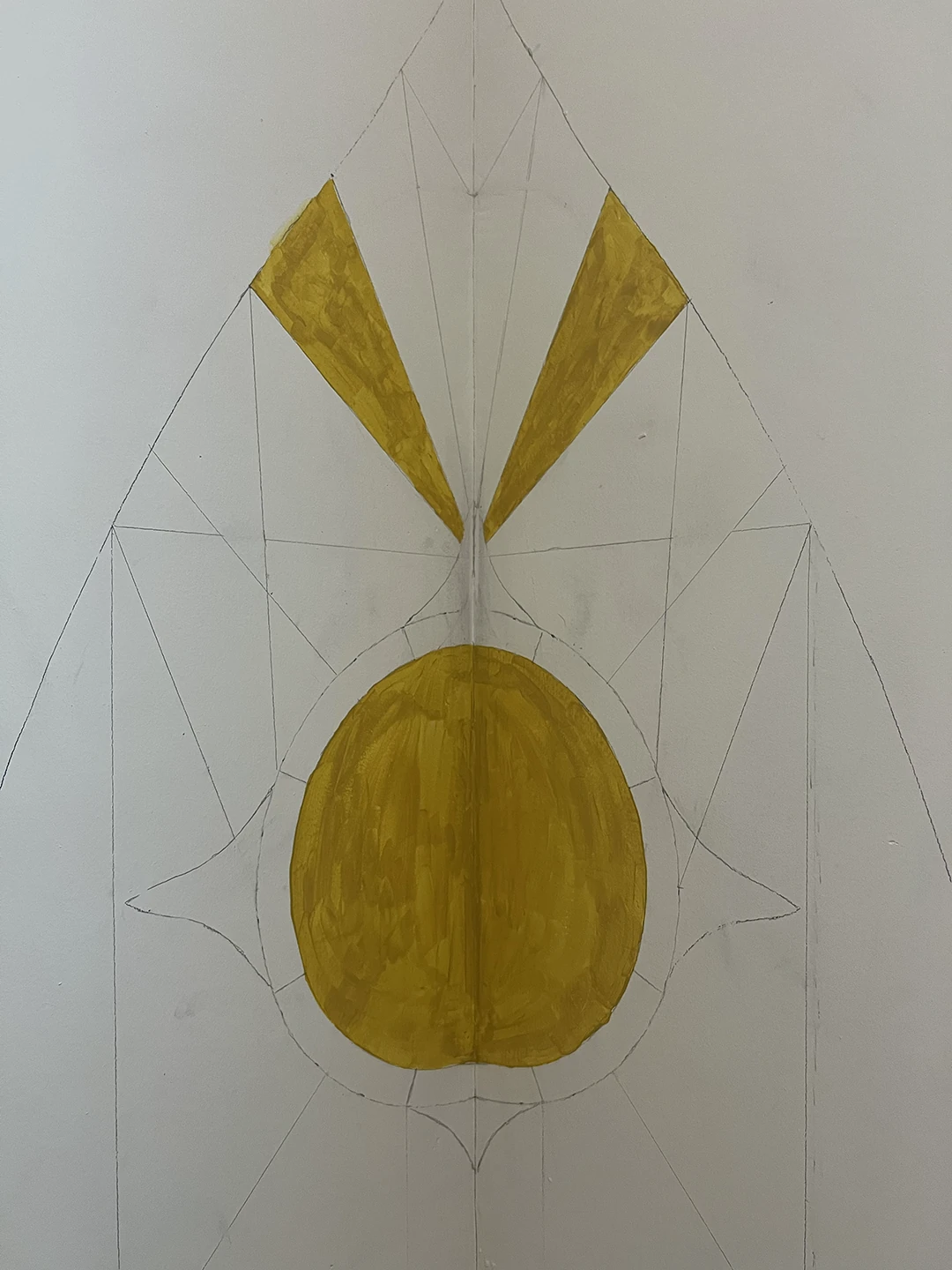 Rabbit shrine process photo showing the mustard-yellow halo circle and two top rays painted on the wall.